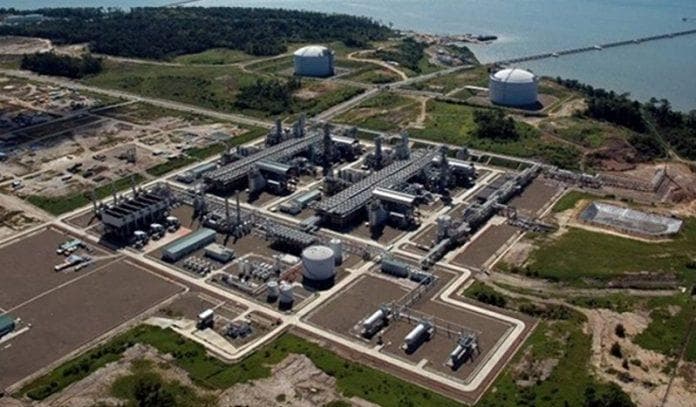 Aerial view of a gas processing plant with LNG storage tanks beside the coast
